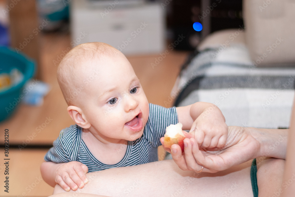 Toddler boy eats a peach with mom's hands. Toddler boy eats a peach with mom's hands.