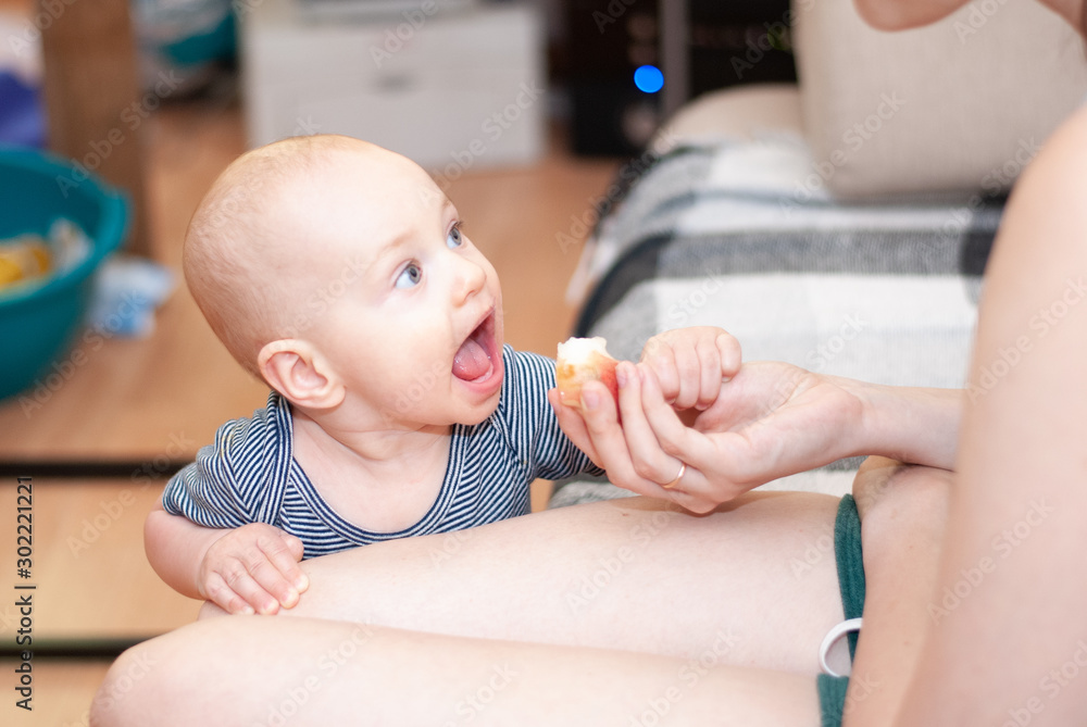 Toddler boy eats a peach with mom's hands. Toddler boy eats a peach with mom's hands.