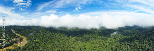 View from above, stunning panoramic view of the Taman Negara village with the tropical rainforest and beautiful soft clouds. Taman Negara National Park, Kuala Tahan, Pahang State, Malaysia.