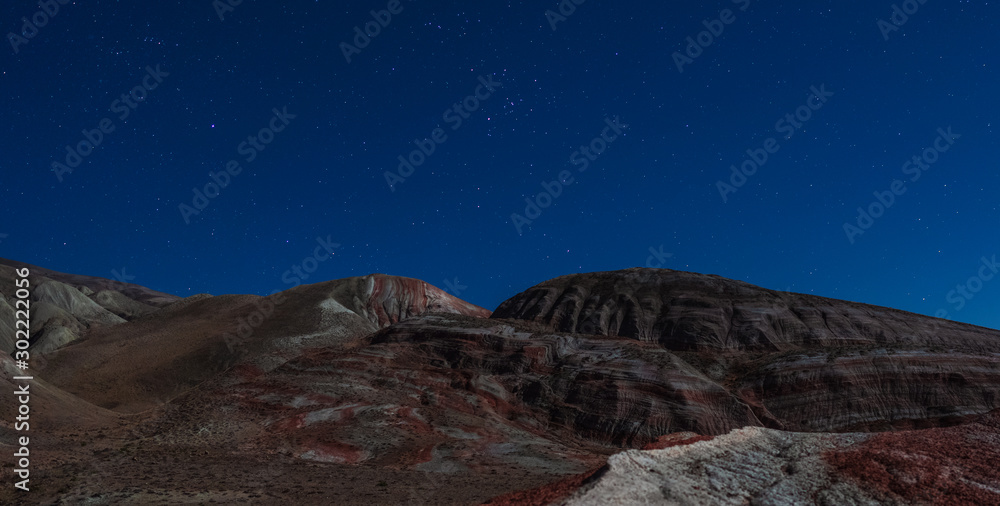 Amazing striped red mountains on a moon night