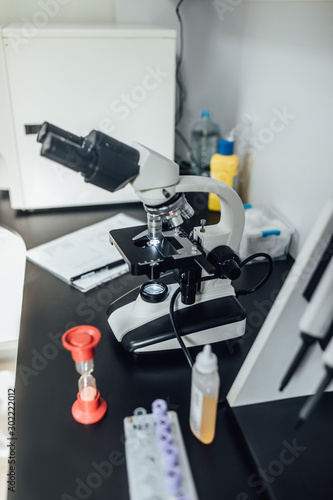 Powerful scientific laboratory microscope with multiple lenses. Biotechnology hardware equipment, white clinic. Blood test,dispenser.