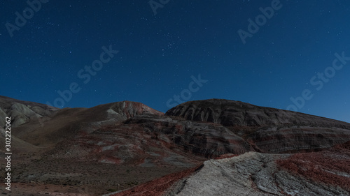 Amazing striped red mountains on a moon night