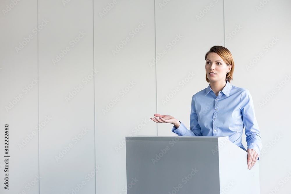 Young business speaker standing in conference room Young business speaker standing in conference room