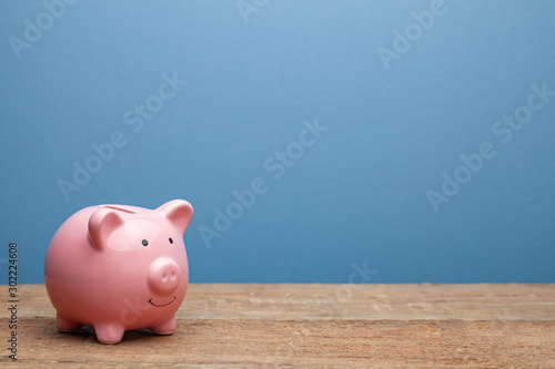 Canvas Print Pink piggy bank on a blue background. Copy space for text.