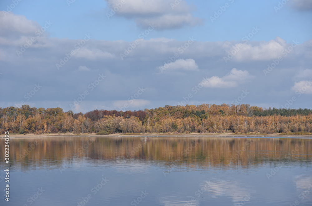 Autumn landscape with forest reflection on the lake in Poland.