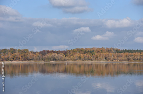 Autumn landscape with forest reflection on the lake in Poland.