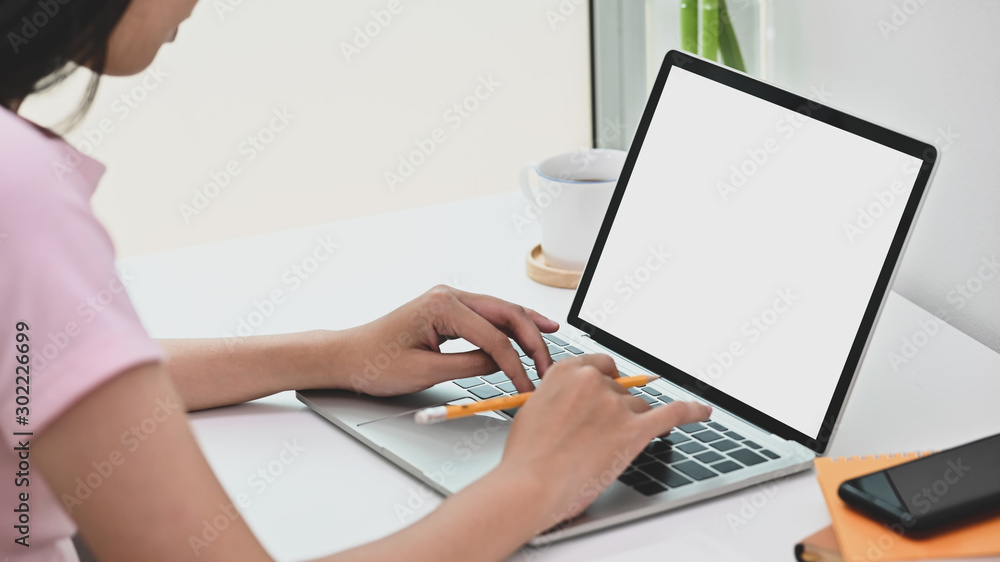 Cropped shot female using her laptop computer with empty screen. Cropped shot female using her laptop computer with empty screen.