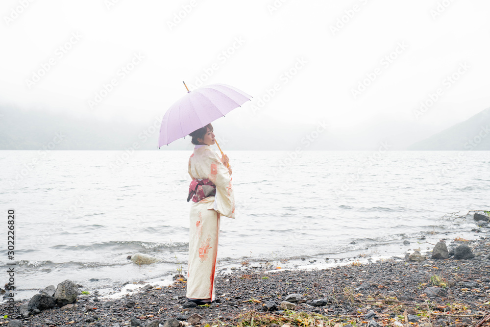 湖畔で傘を持つ着物の女性