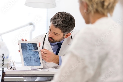 Doctor showing x-ray result to patient in clinic