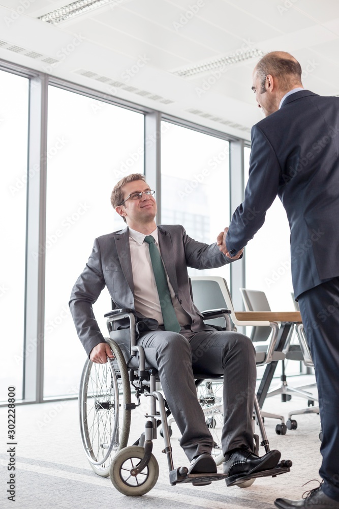 Businesman shaking hands with business partner in office Businesman shaking hands with business partner in office