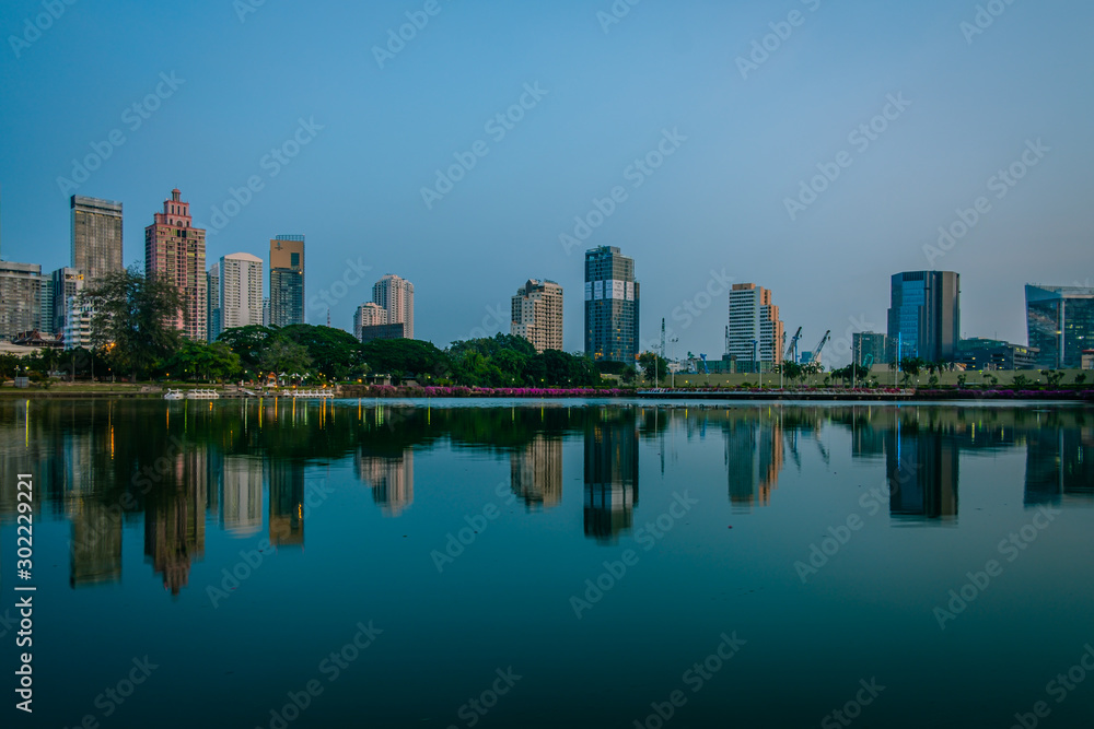 BANGKOK, THAILAND - 7 Nov 2019  :Reflection office building water front a Benjakiti green park