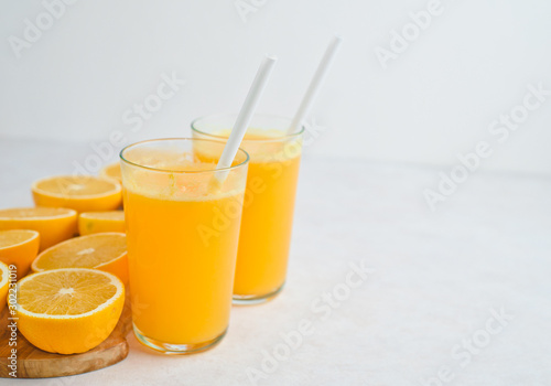 Glass of freshly squeezed orange juice and slices of orange fruit isolated on white background
