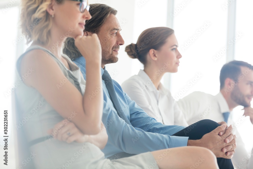 Business people sitting while listening on meeting in office
