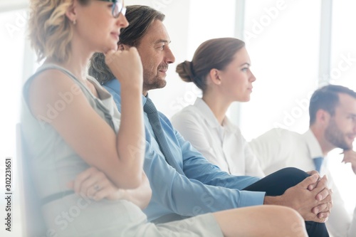Business people sitting while listening on meeting in office