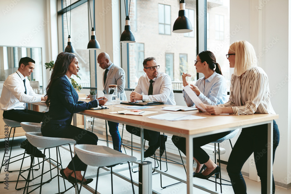 Diverse group of businesspeople talking together around an offic