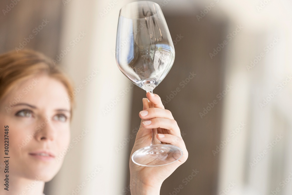 Closeup of young waitress looking at empty wineglass in restaurant Closeup of young waitress looking at empty wineglass in restaurant