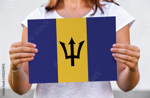 woman holds flag of Barbados on paper sheet