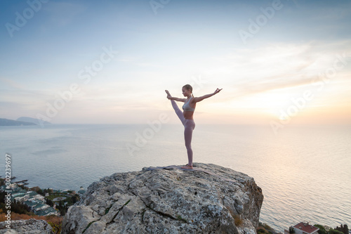 girl practices yoga at sunrise