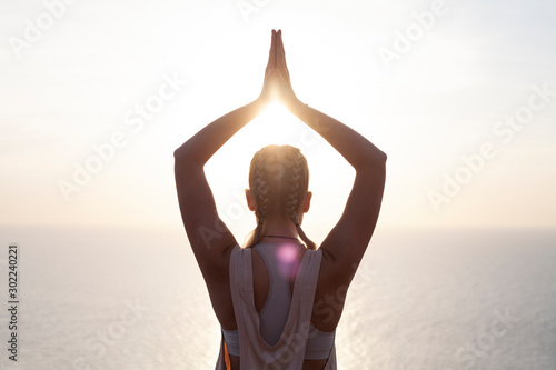 girl practices yoga at sunrise