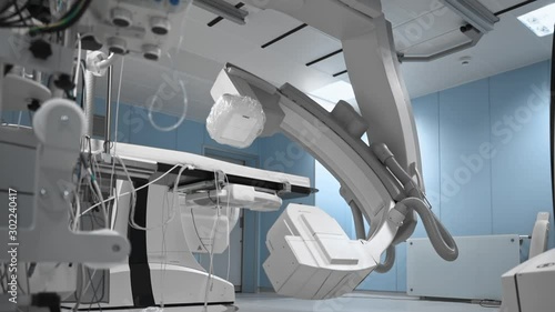 Modern medical robot for human diagnostic in operating room. Robotic medicine. Empty sterile operating room, rotating parts of futuristic device