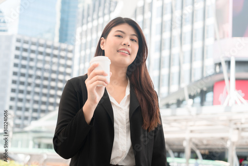 Asian business woman holding coffee papercup enjoy at outdoor office.
