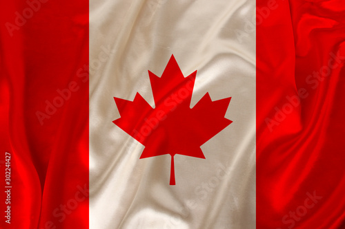 photo of the national flag of Canada on a luxurious texture of satin, silk with waves, folds and highlights, closeup, copy space, illustration