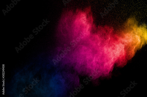 Colorful powder explosion on black background. Abstract pastel color dust particles splash. photo
