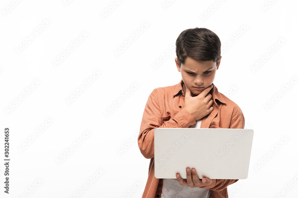thoughtful boy looking at laptop and holding hand near face isolated on white thoughtful boy looking at laptop and holding hand near face isolated on white
