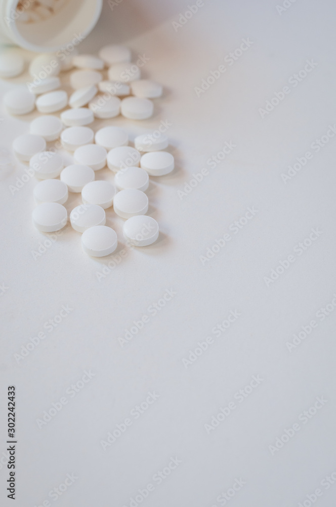 white pills on white background spilling out of bottle,Melatonin to help sleep. white pills on white background spilling out of bottle,Melatonin to help sleep.