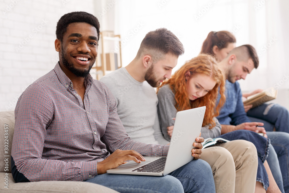 Afro man with laptop preparing for exam and smiling Afro man with laptop preparing for exam and smiling