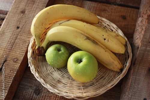 Green apples and bananas on the table