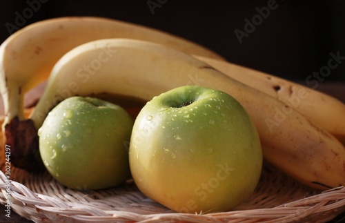 Green apples and bananas on the table