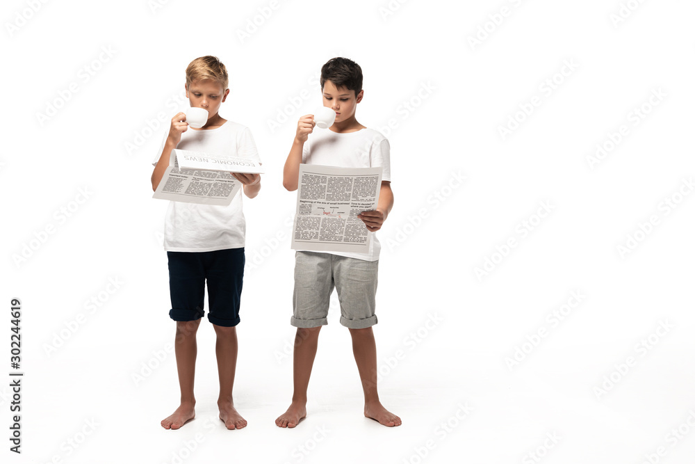 two brothers reading newspapers and drinking coffee on white background two brothers reading newspapers and drinking coffee on white background