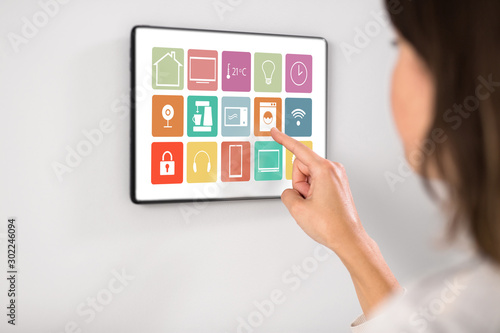 automation, internet of things and technology concept - woman using menu icons on tablet pc computer screen at smart home