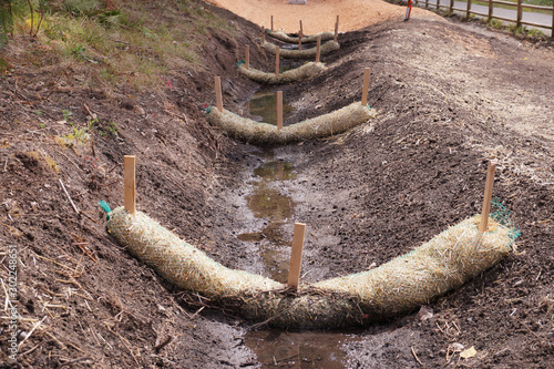 Fotografija The use of straw wattles. Land drainage works.