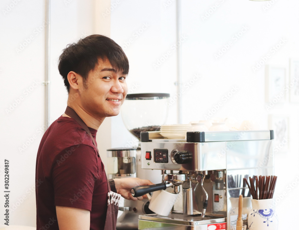 Asian young man making coffee at the coffee machine. Asian young man making coffee at the coffee machine.
