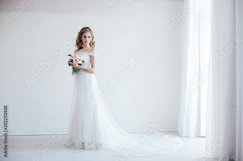 bride in wedding dress holding a bouquet of flowers photo