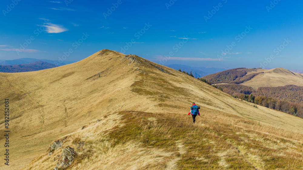 life style hiking mountain ridge panorama in Slovakia Tatras with backpacker woman in warm cloth walking on highland dramatic scenery landscape environment clear day weather time, copy space   