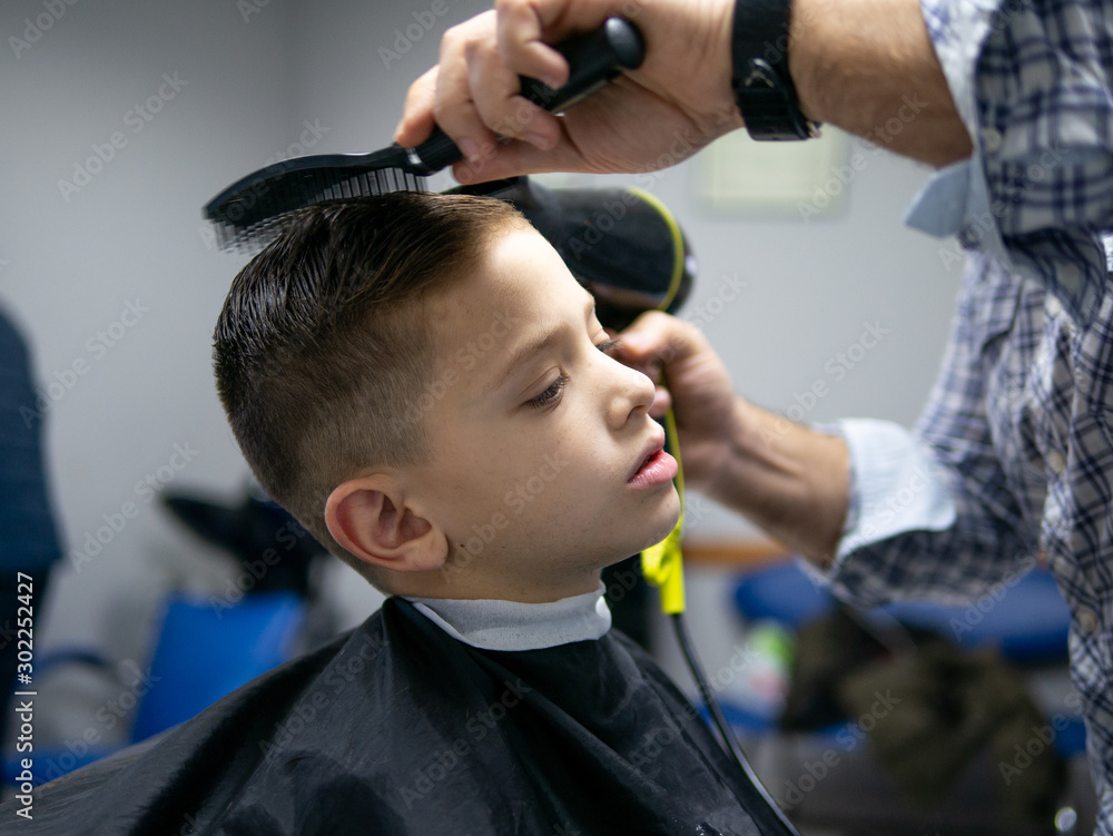 young boy at the hairdresserhaving his hair cut young boy at the hairdresserhaving his hair cut