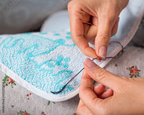 Woman sews up clothes. Hands seamstress close-up. Mending clothes.