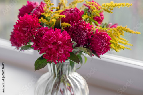 Wallpaper Mural Bouquet of magenta dahlias. Fresh bunch purple pink with yellow peonies roses flower in glass vase on the window sill, white background. Autumn time concept. Still life, rustic style. Torontodigital.ca