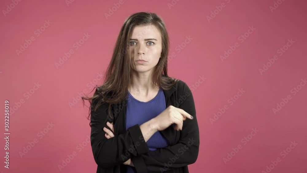 Portrait of a strict woman with finger on lips. Young woman asking for silence making a hush gesture. Portrait of a strict woman with finger on lips. Young woman asking for silence making a hush gesture.