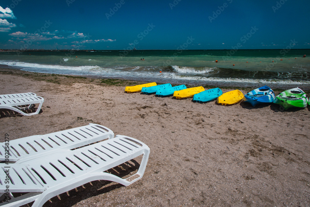 Sun loungers and kayaks on the beach Sun loungers and kayaks on the beach