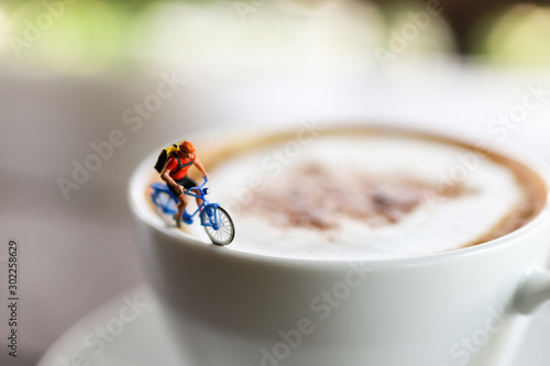 Miniature people : Coffee cup with cycling, image use for charge your energy in the morning
