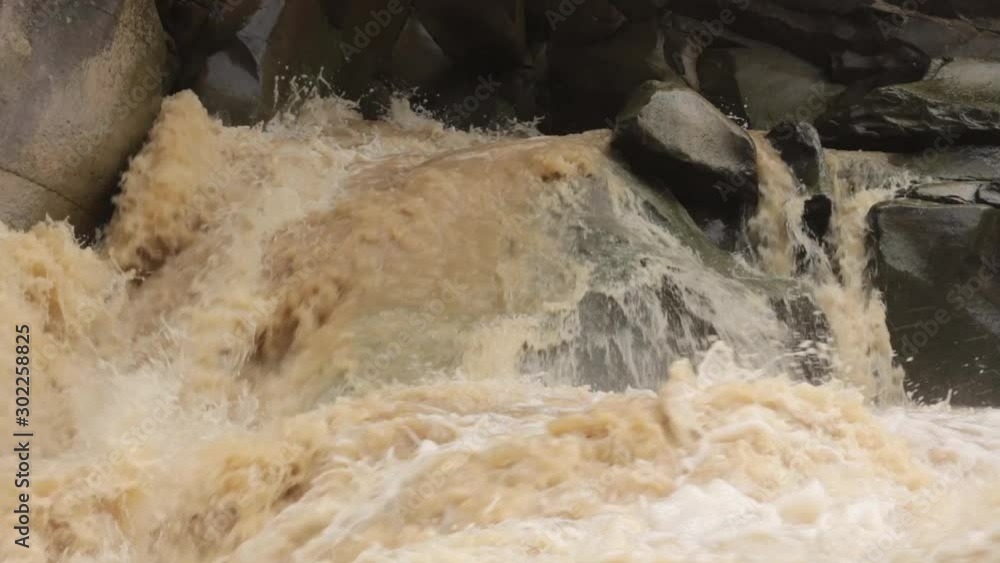 fast stream of dirty water in river rapids and waterfall fast stream of dirty water in river rapids and waterfall