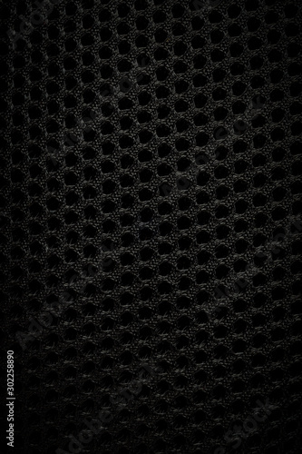 Background of black fabric with texture and tech holes, vertical image