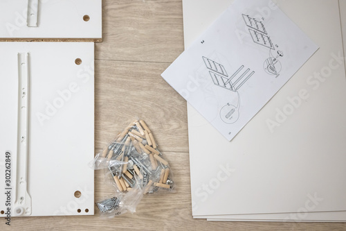 Furniture assembly parts and tools for self assembly furniture, on the floor. instructions for furniture assembling with tools