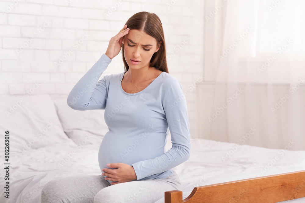 Pregnant Lady Having Headache Sitting On Bed In Bedroom Pregnant Lady Having Headache Sitting On Bed In Bedroom