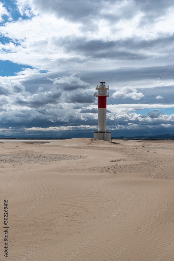 Lighthouse by the sea in the middle of the desert. Brown, blue and gray colors