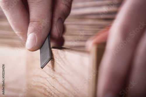 carpenter using rasp or file handles wooden oak plank